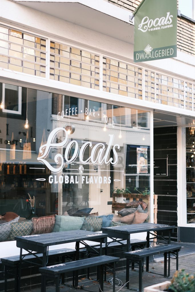 Cozy coffee shop with outdoor seating and global flavors in urban area.